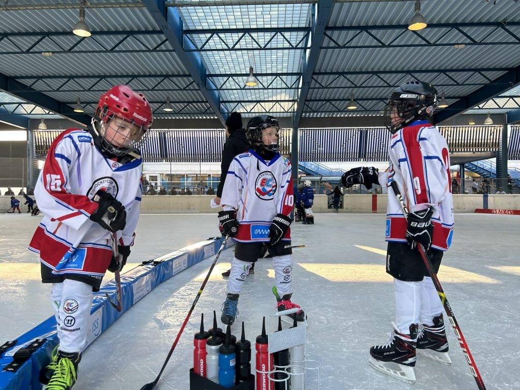 Junge Eishockeyspieler beim Training an der Bande